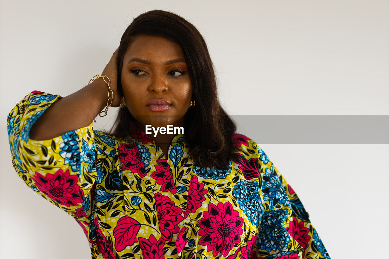 portrait, one person, studio shot, adult, looking at camera, women, indoors, photo shoot, front view, white background, clothing, young adult, waist up, hairstyle, sleeve, copy space, serious, emotion, standing, black hair, female, headshot, pattern, multi colored, fashion, gray background, cut out, person, looking, long hair