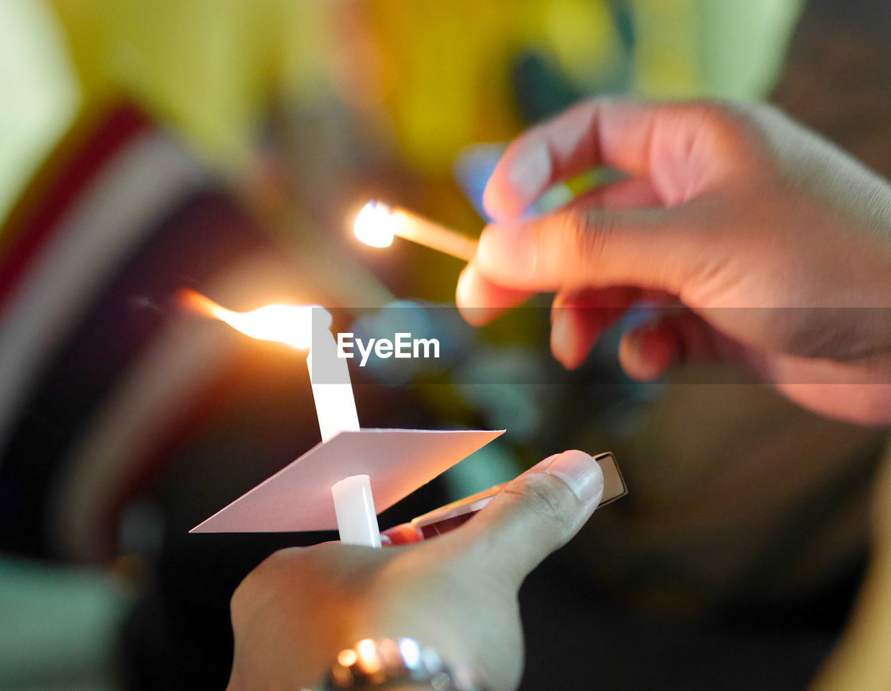 Close-up of hand holding lit candles