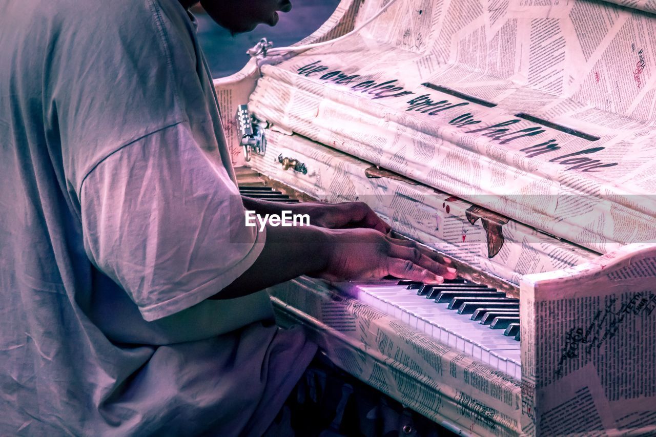 Side view of man playing piano