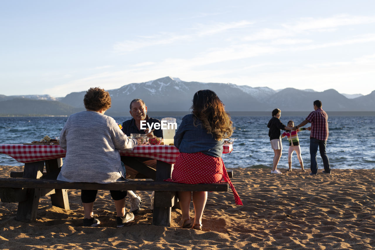 A family enjoys a beach picnic on the shoreline of lake tahoe, nv