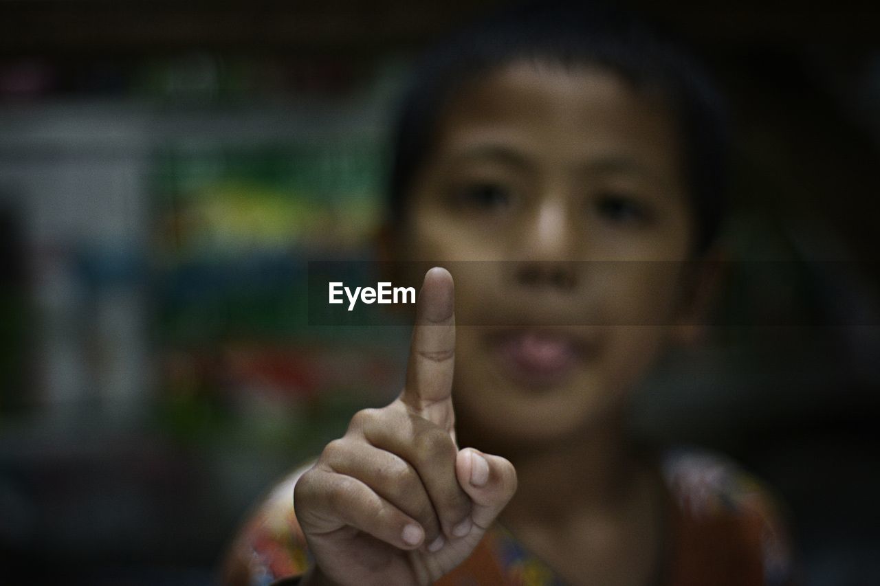 Close-up of boy pointing at camera