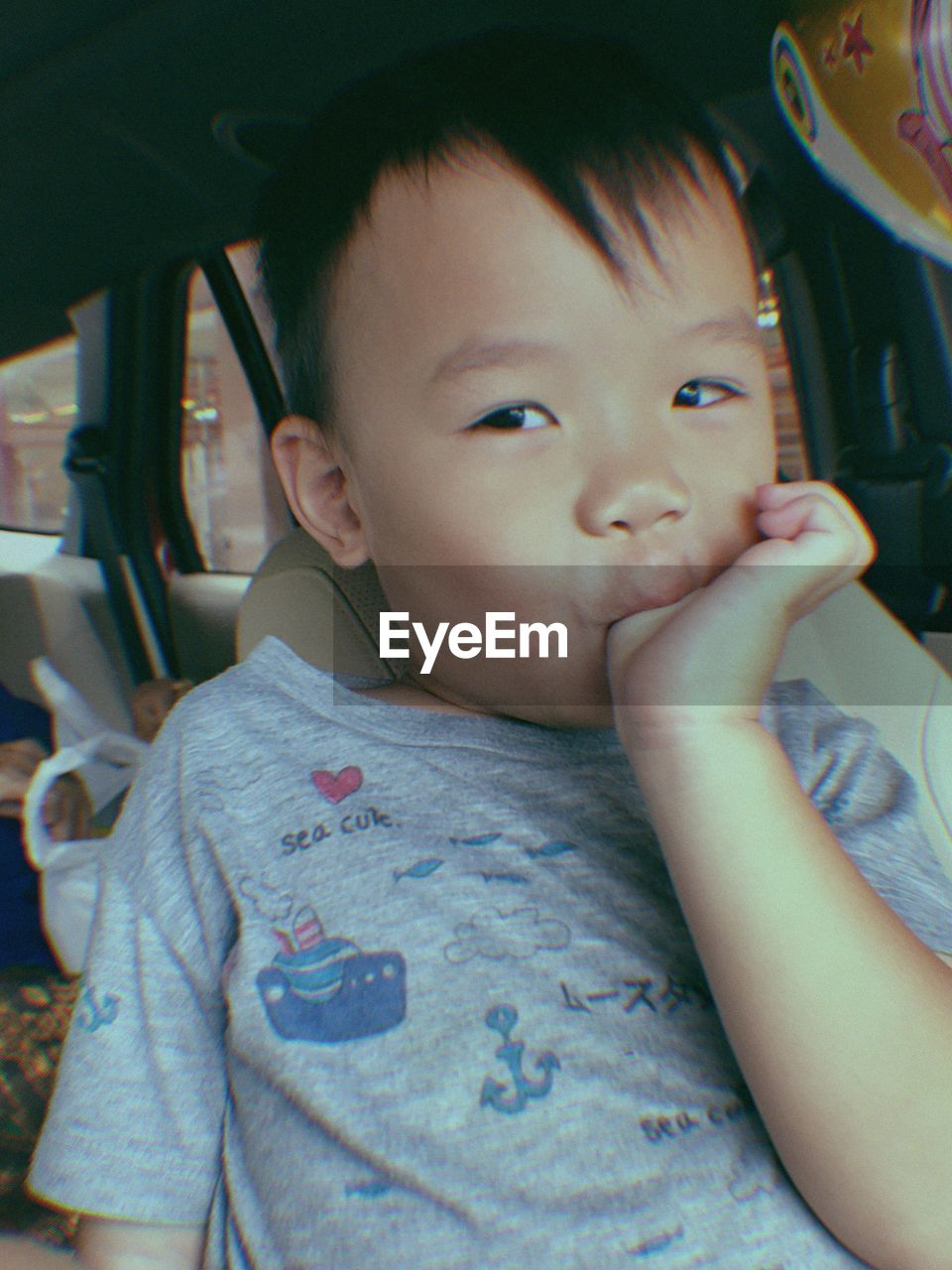 Portrait of boy sucking thumb in car