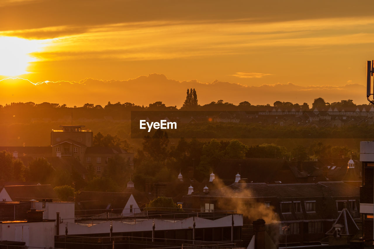 Panoramic view of colchester buildings against sky during golden summer sunset 