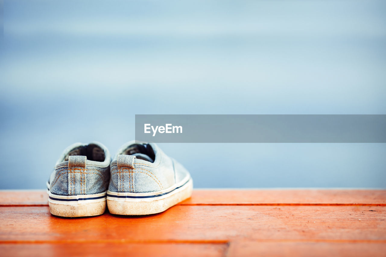 CLOSE-UP OF SHOES ON WOOD