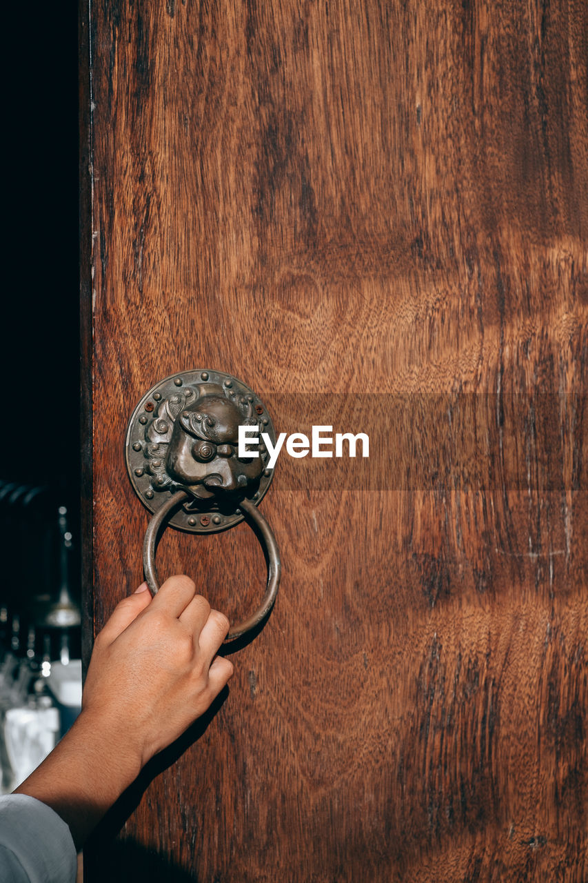 Close-up of human hand holding door knocker