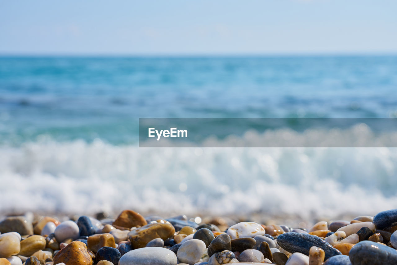 Surface level of stones at beach against sky