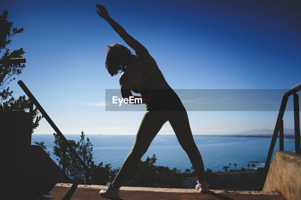 Girl stretching on top of the sea