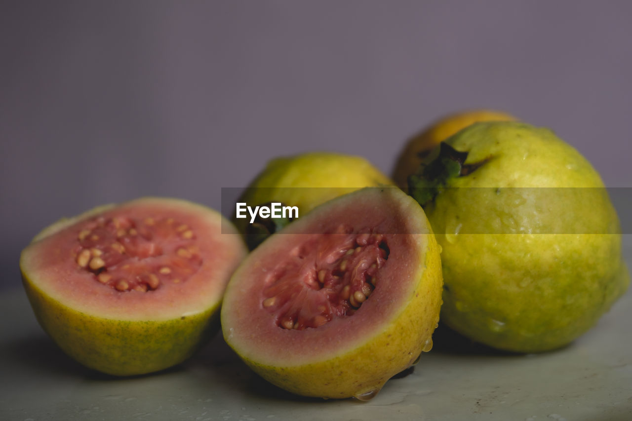 food and drink, food, healthy eating, fruit, freshness, wellbeing, plant, studio shot, produce, indoors, no people, close-up, cross section, group of objects, slice, still life, halved, focus on foreground, two objects, colored background, three objects, citrus