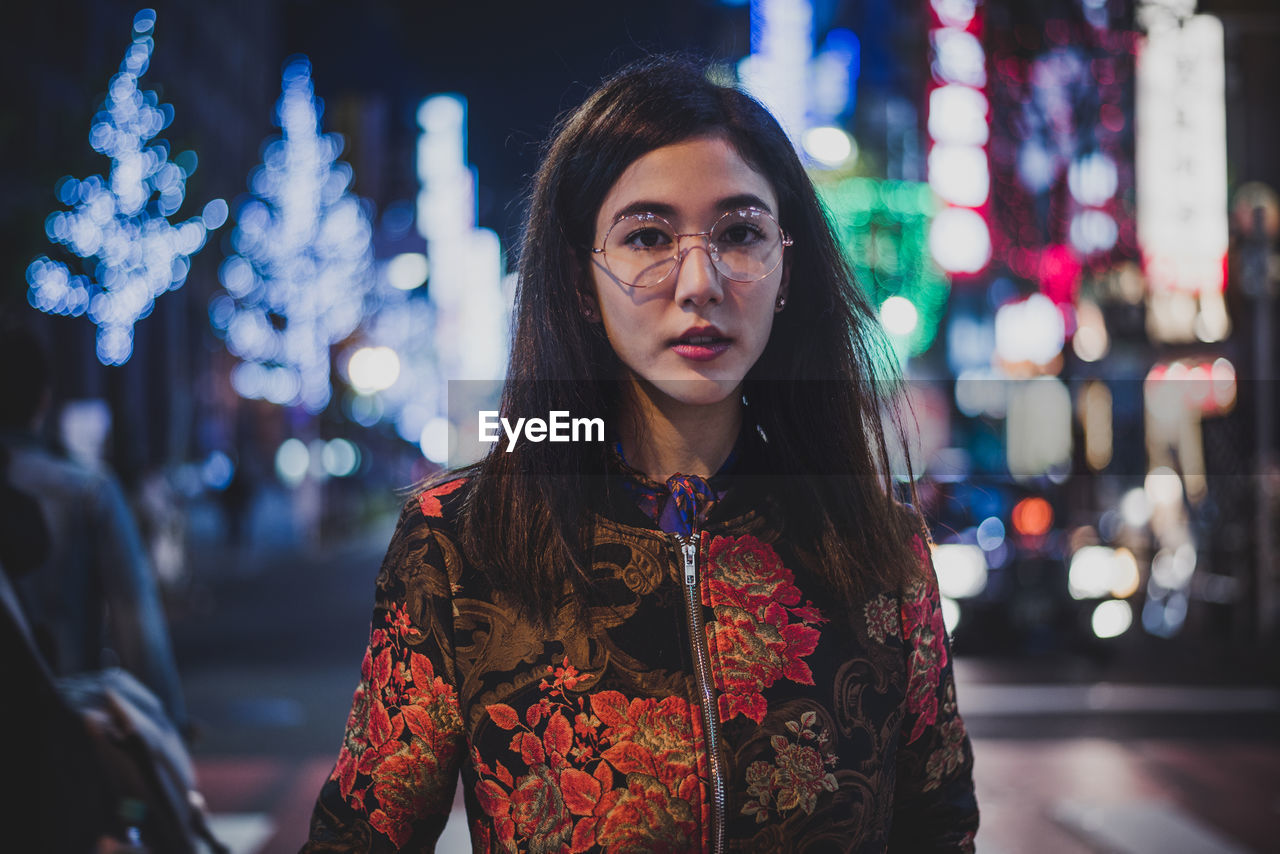 PORTRAIT OF WOMAN STANDING AT NIGHT