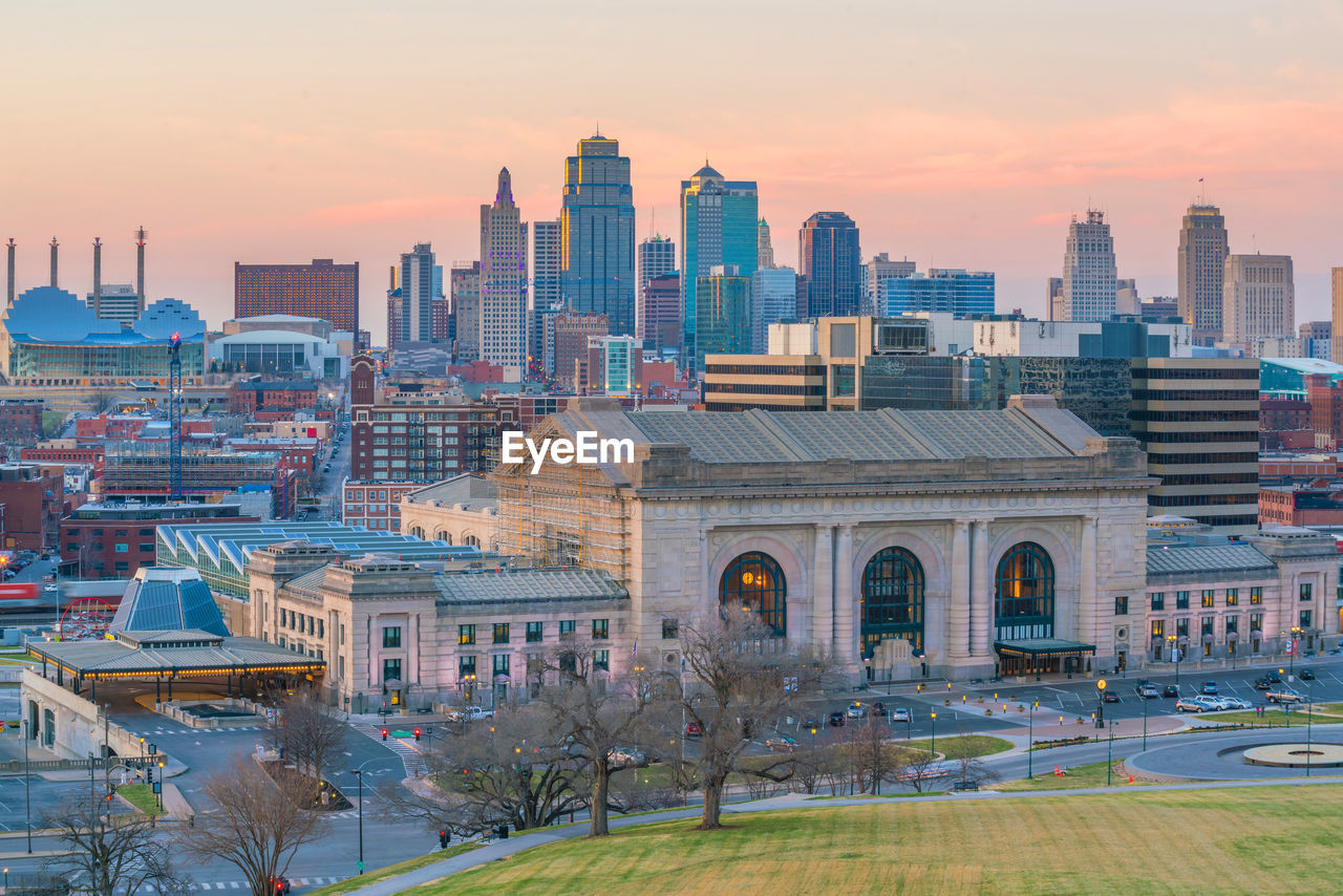 BUILDINGS IN CITY AGAINST SKY DURING SUNSET