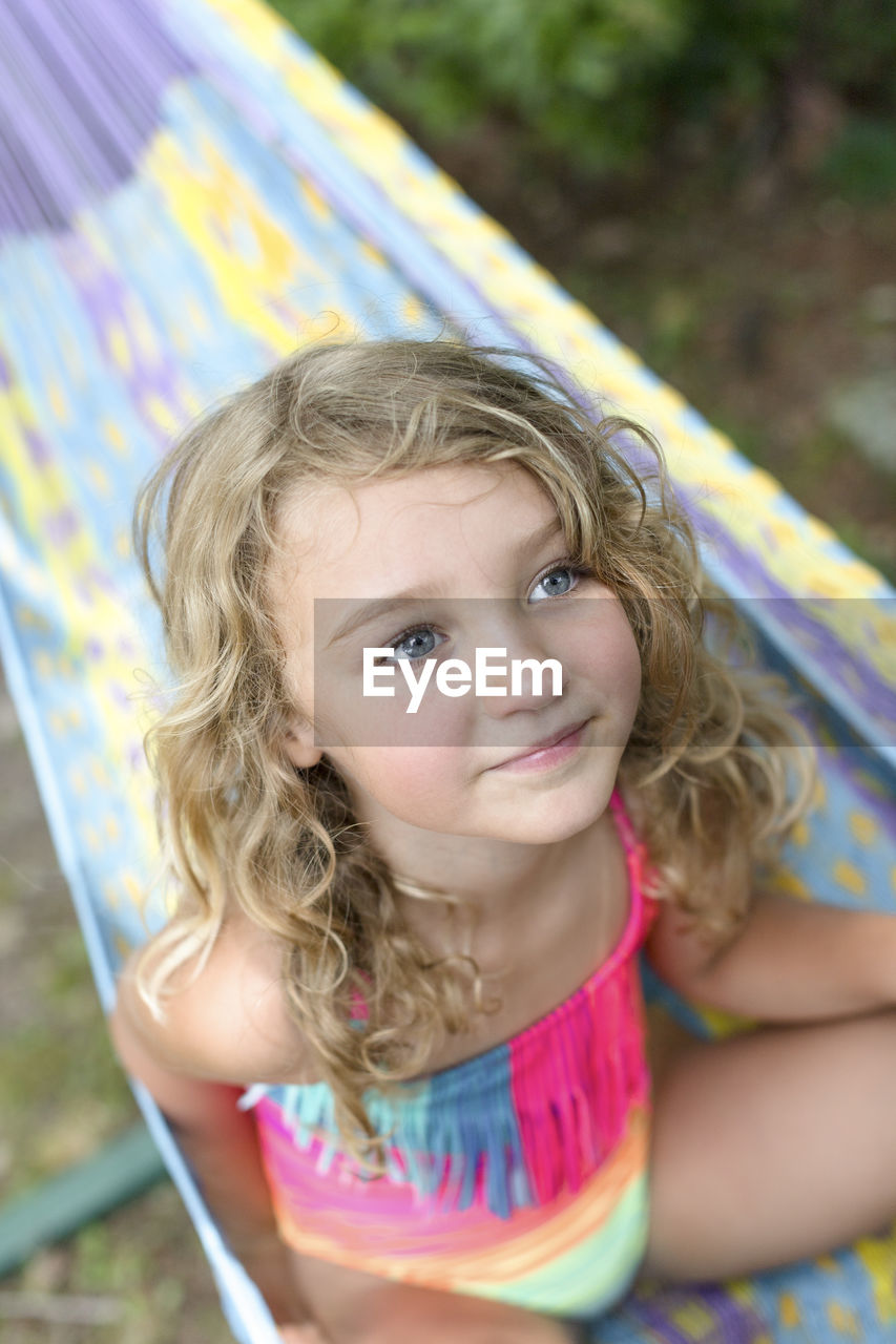 Child with blue eyes in a colorful hammock