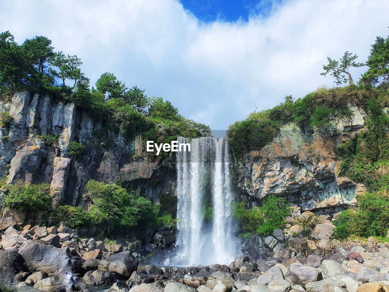 Scenic view of waterfall against sky