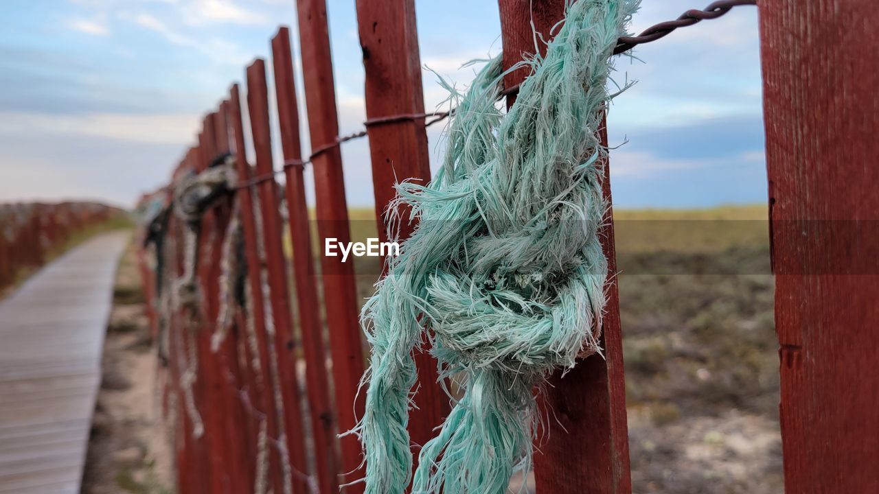 CLOSE-UP OF ROPE ON WOODEN POST