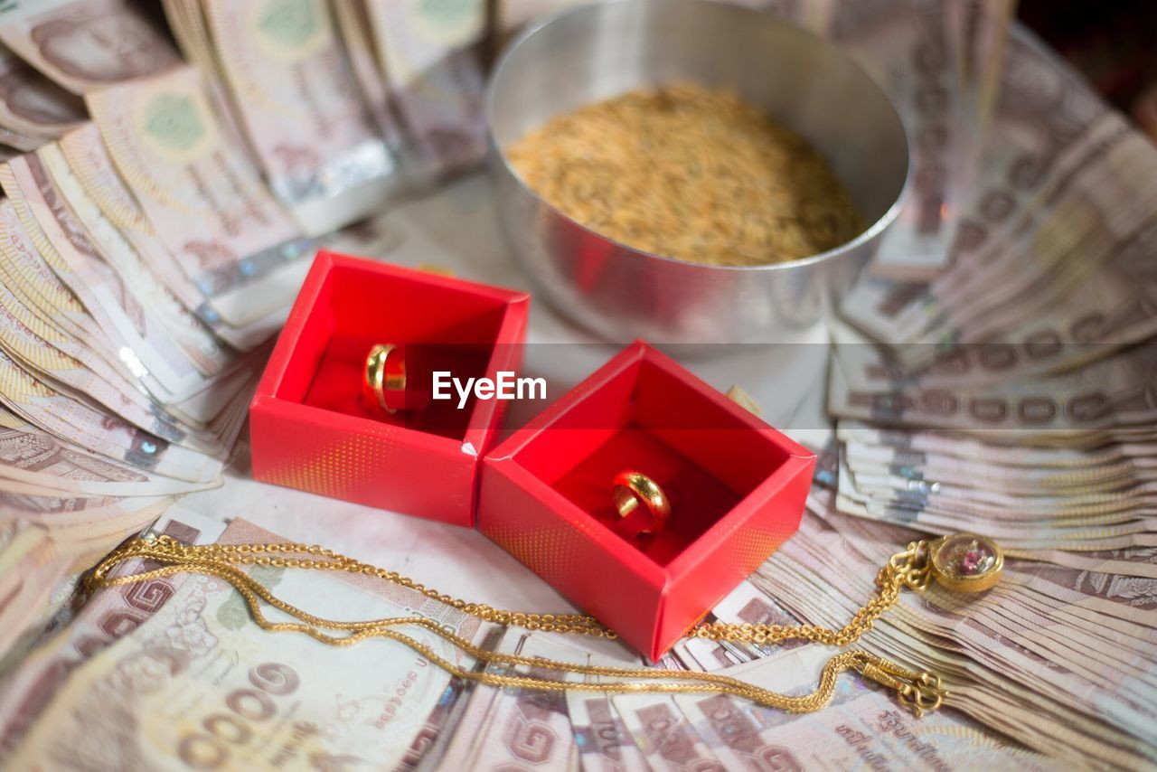 High angle view of jewelry and paper currencies in plate