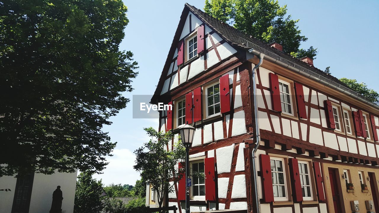 LOW ANGLE VIEW OF HOUSE AGAINST TREES