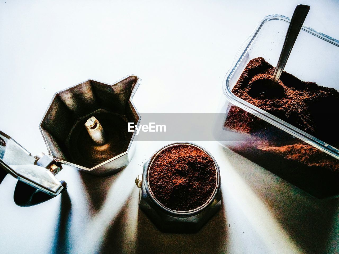 High angle view of ground coffee with maker on table