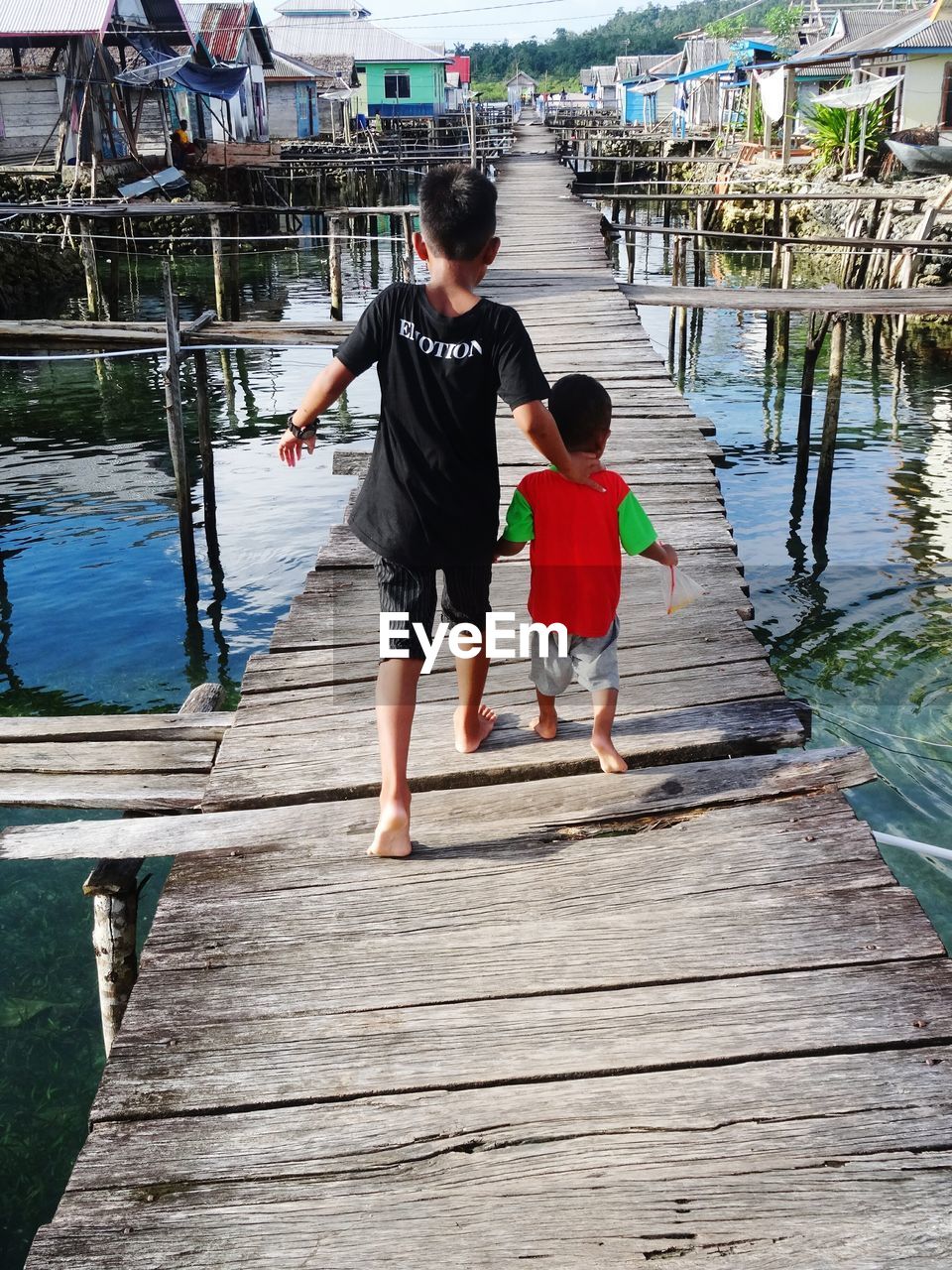 TWO PEOPLE WALKING ON PIER