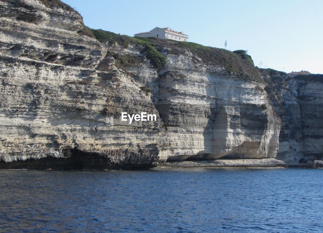 Rock formations in sea against clear sky