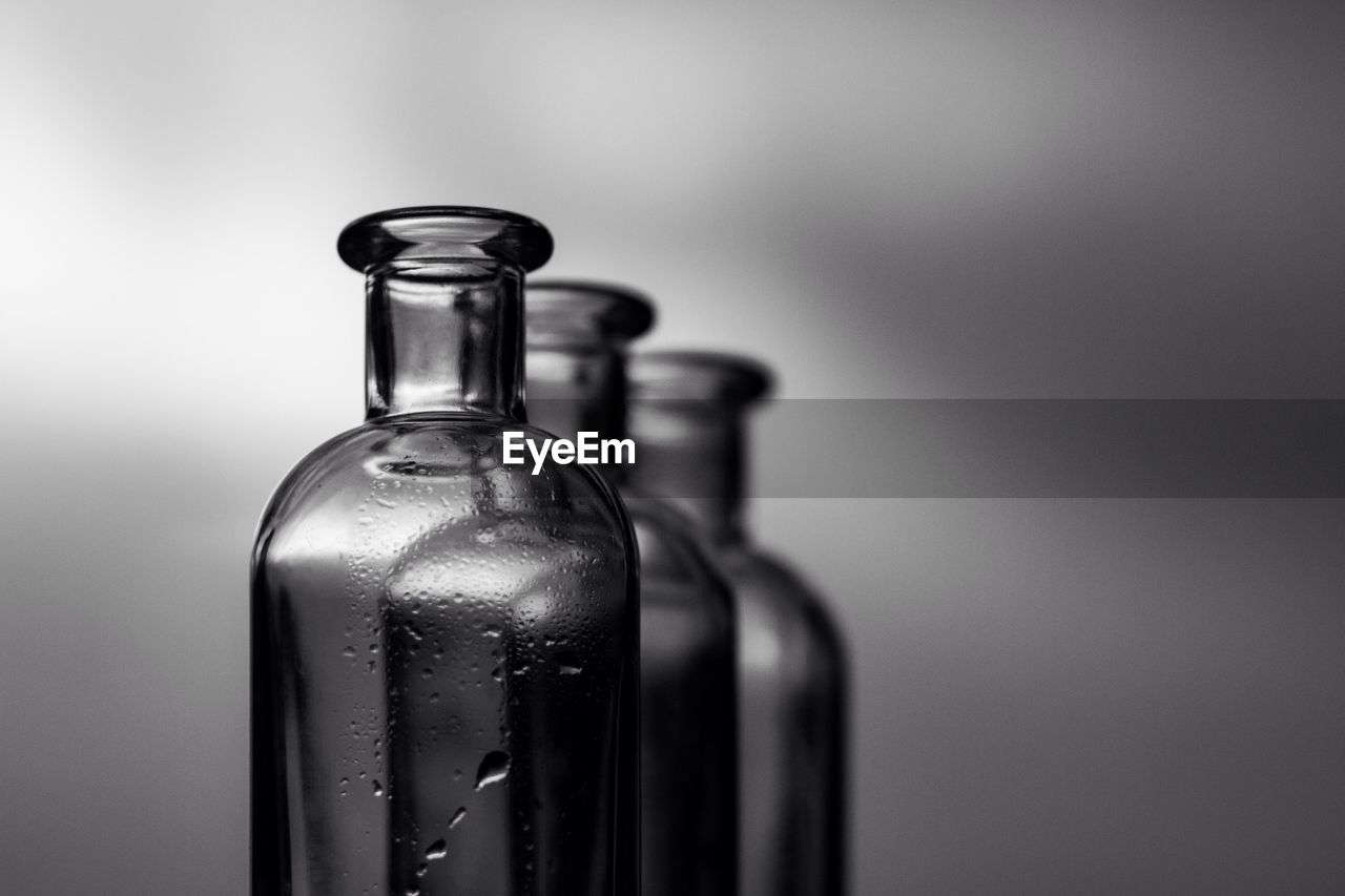 Close-up of three glass bottle against blurred background