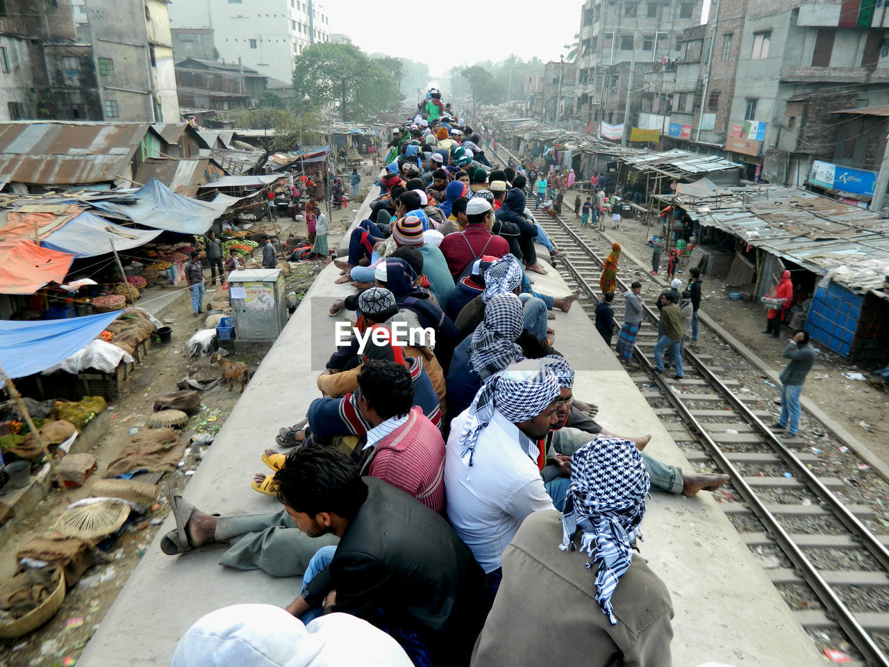 People sitting on train rood in city