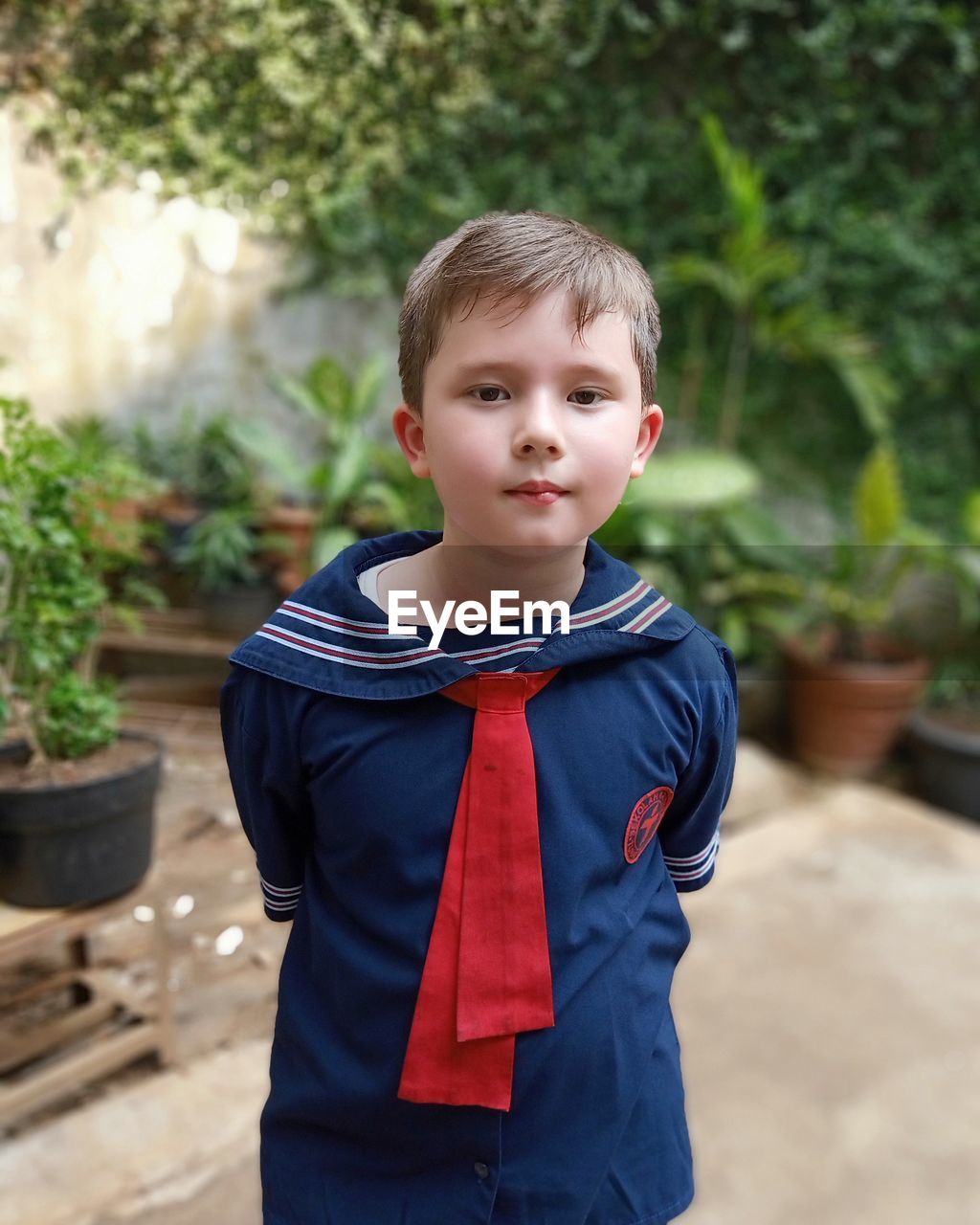 PORTRAIT OF BOY STANDING AGAINST WALL