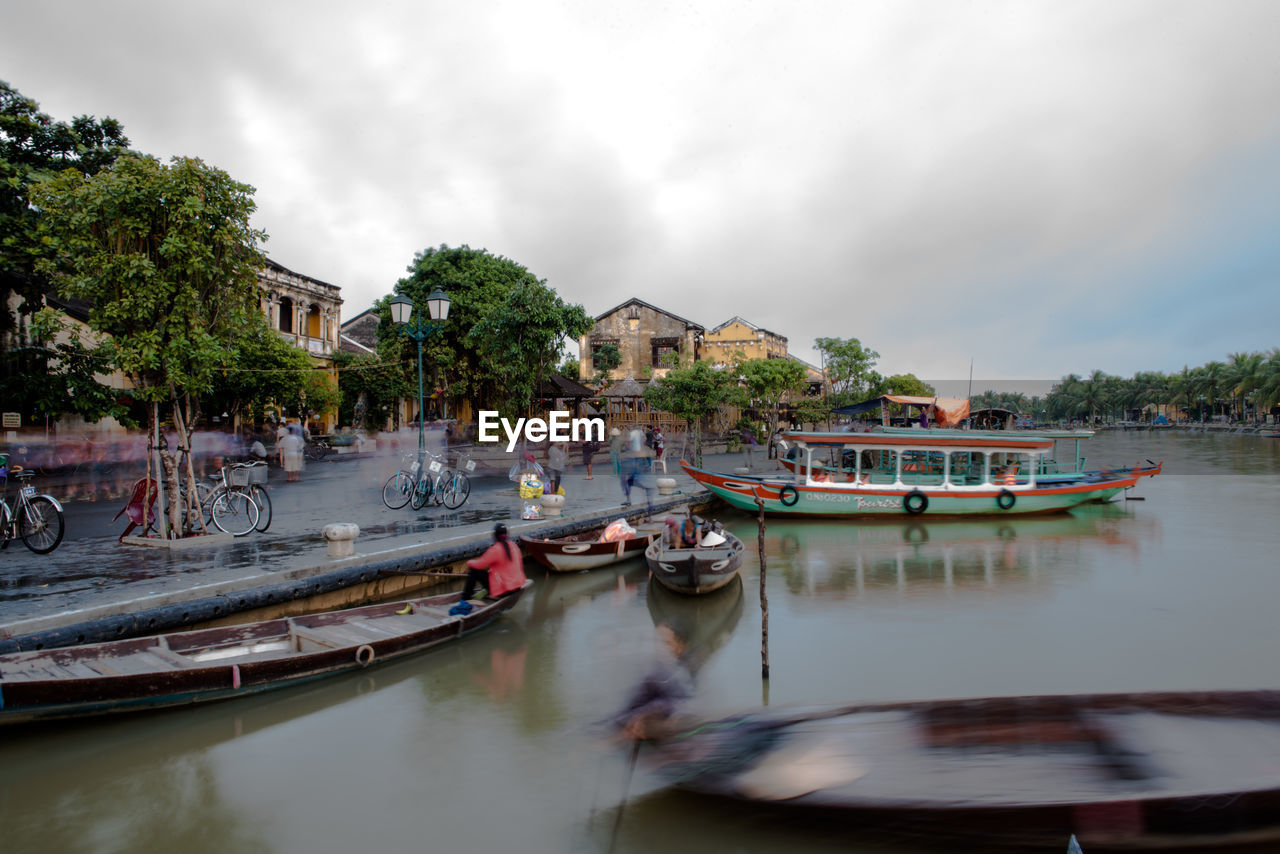 Boats moored in canal against sky