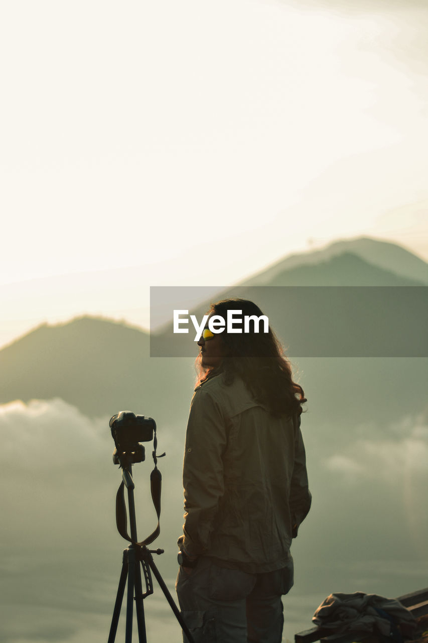 Man with camera and tripod on mountain