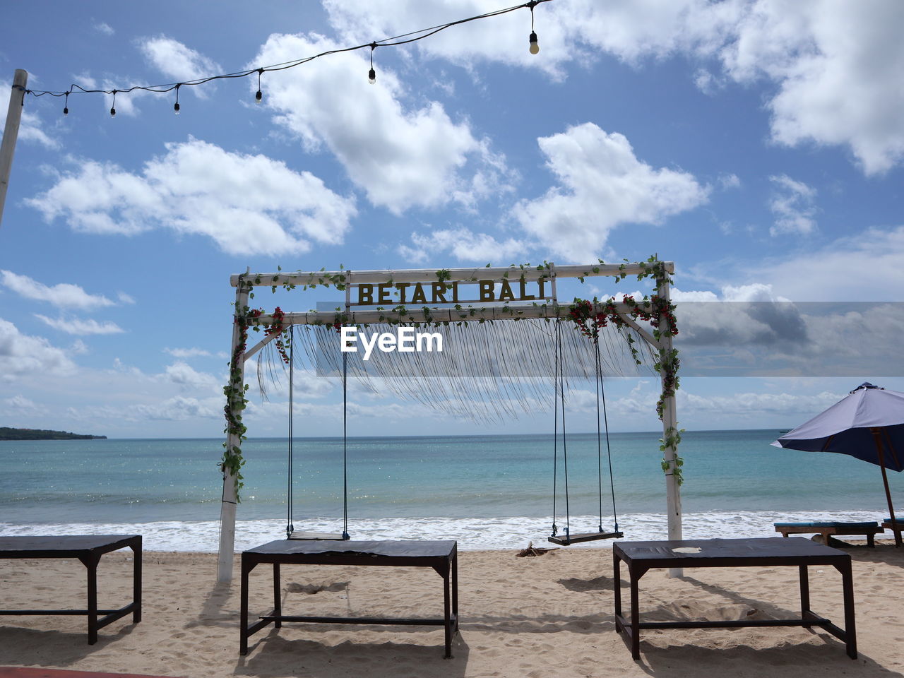 sky, water, sea, beach, cloud, nature, land, seat, tranquility, beauty in nature, day, scenics - nature, no people, chair, vacation, travel destinations, absence, holiday, tranquil scene, outdoors, trip, horizon over water, architecture, horizon, sand, empty, blue, summer, idyllic, travel, wood, sunlight