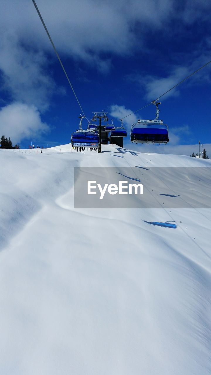 Low angle view of overhead cable cars on snowcapped mountain