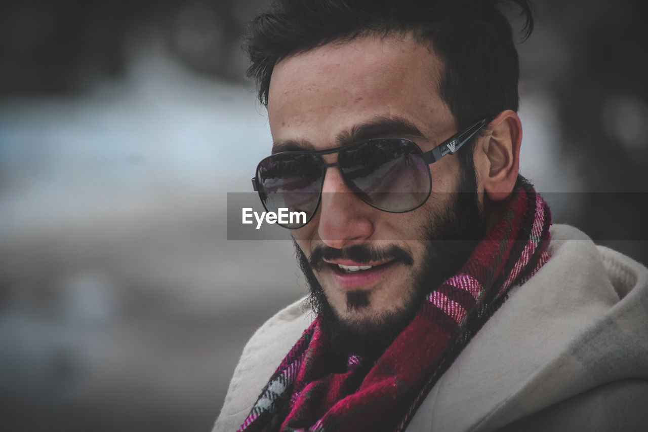 CLOSE-UP PORTRAIT OF YOUNG MAN WEARING SUNGLASSES