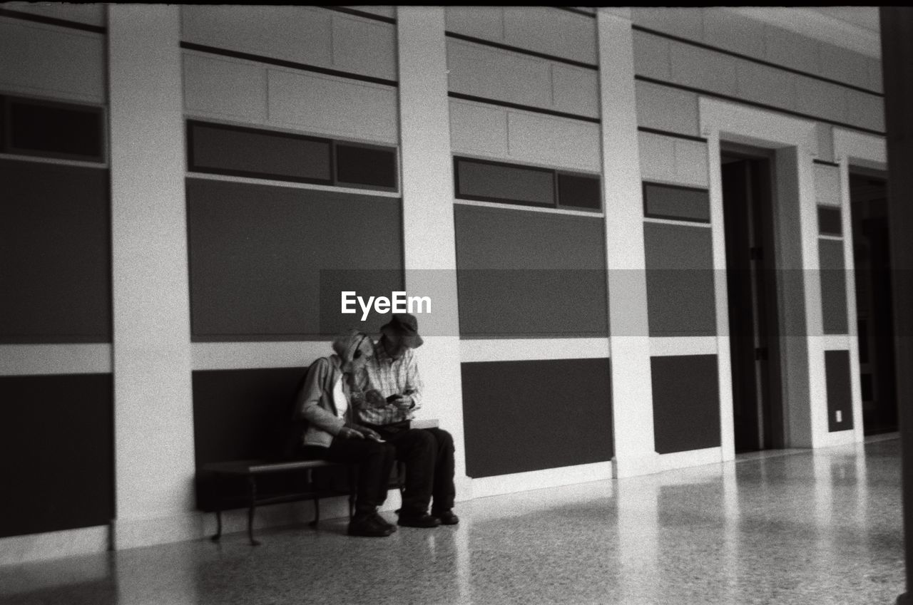 PEOPLE SITTING IN FRONT OF BALCONY AT YARD