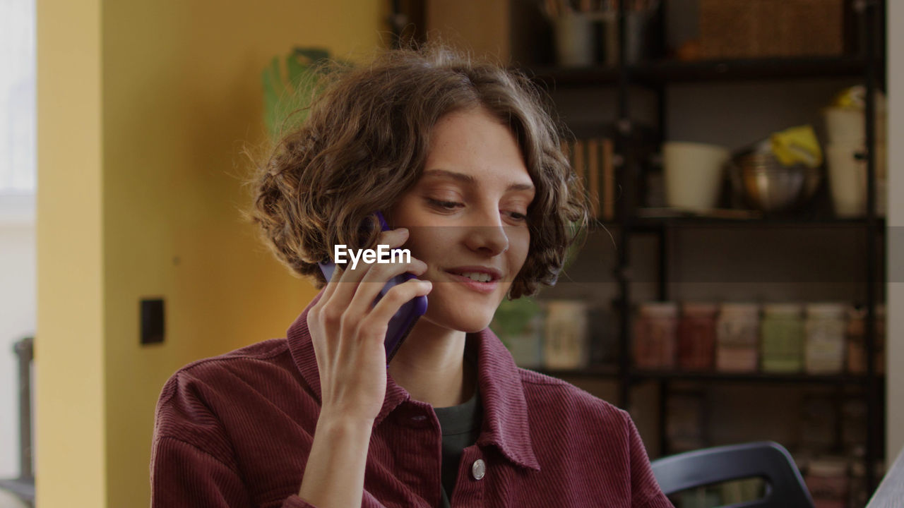 Young woman using mobile phone at home