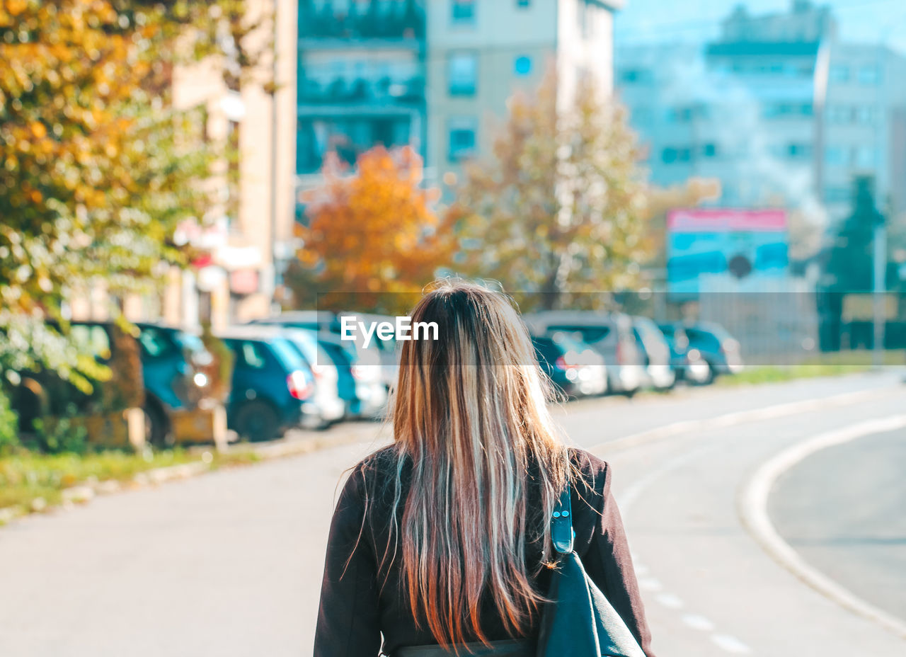 Rear view of woman walking on street in city