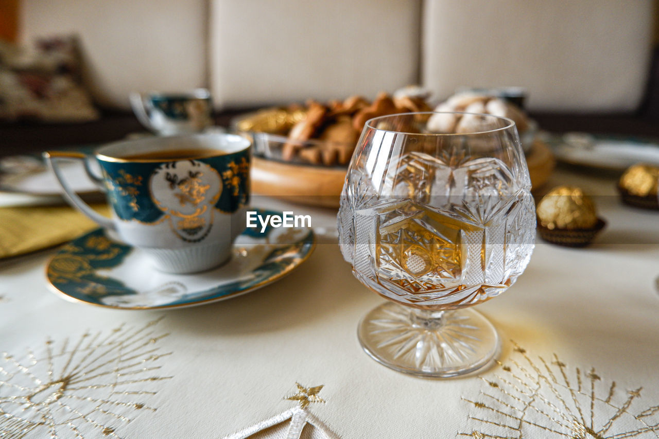 table, food and drink, indoors, crockery, mug, cup, drink, no people, tea cup, porcelain, serveware, tea, hot drink, tableware, saucer, still life, meal, ceramic, close-up, focus on foreground, tradition, gold, food, refreshment