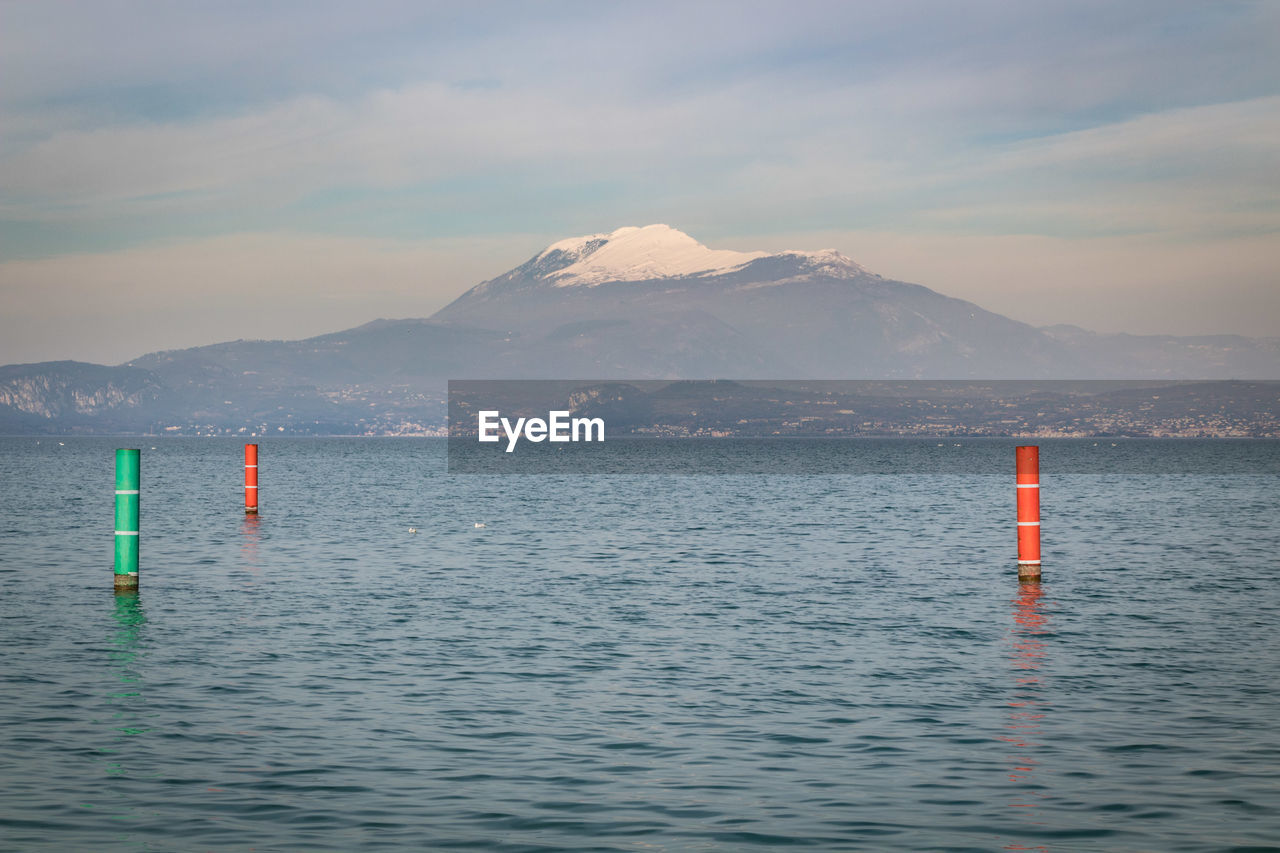 SCENIC VIEW OF SEA AGAINST MOUNTAIN