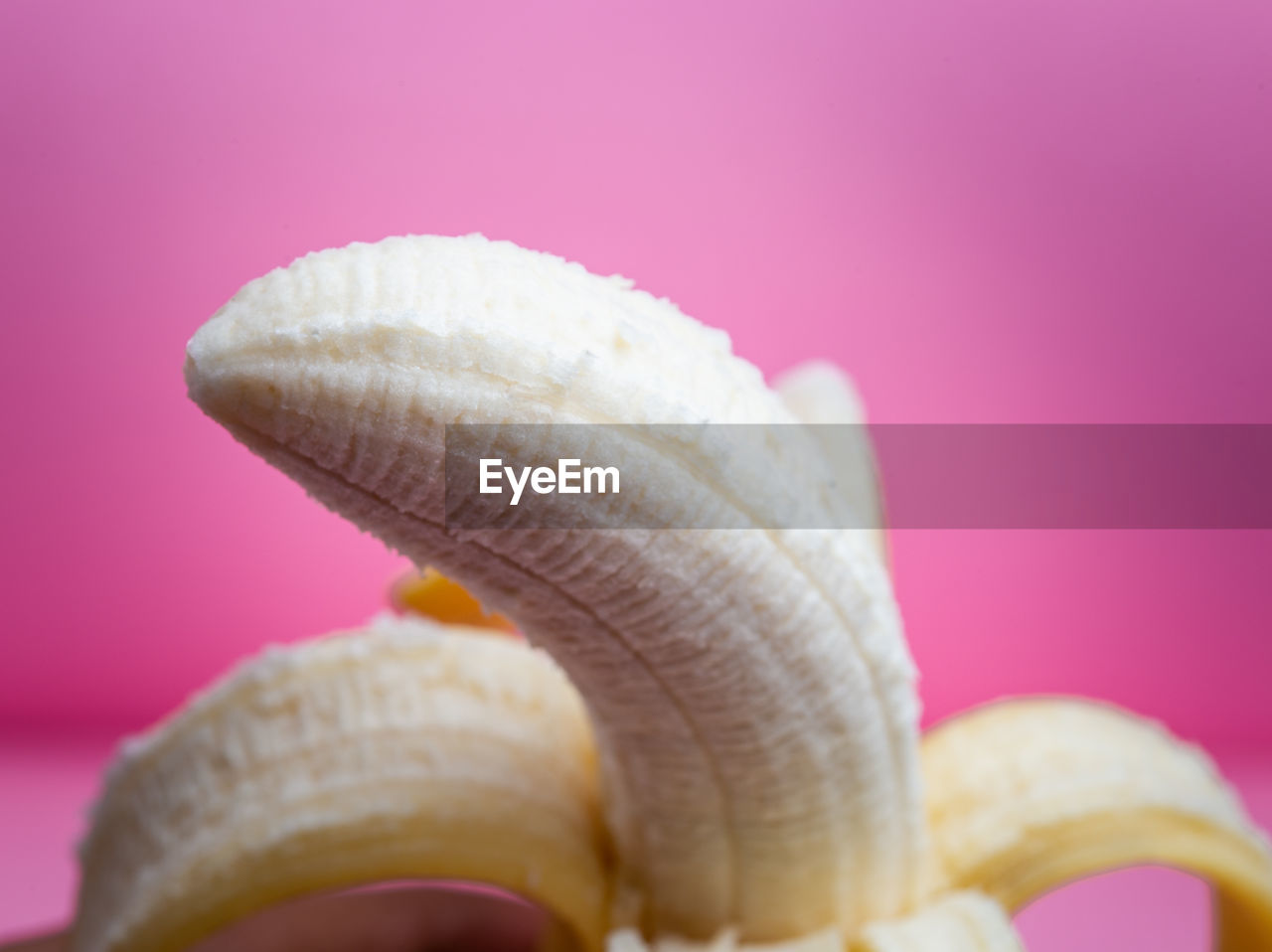 Close-up of banana against pink background