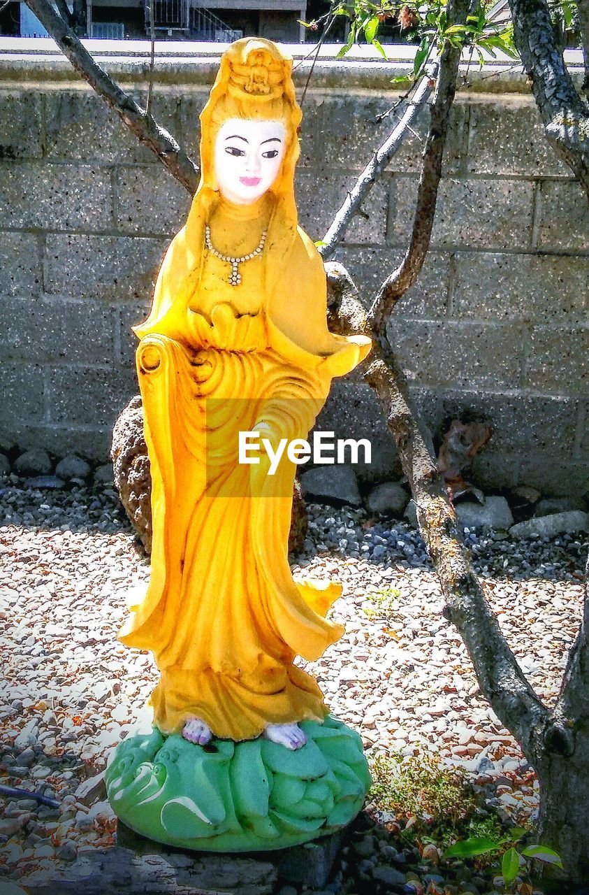 CLOSE-UP OF BUDDHA STATUE ON WALL