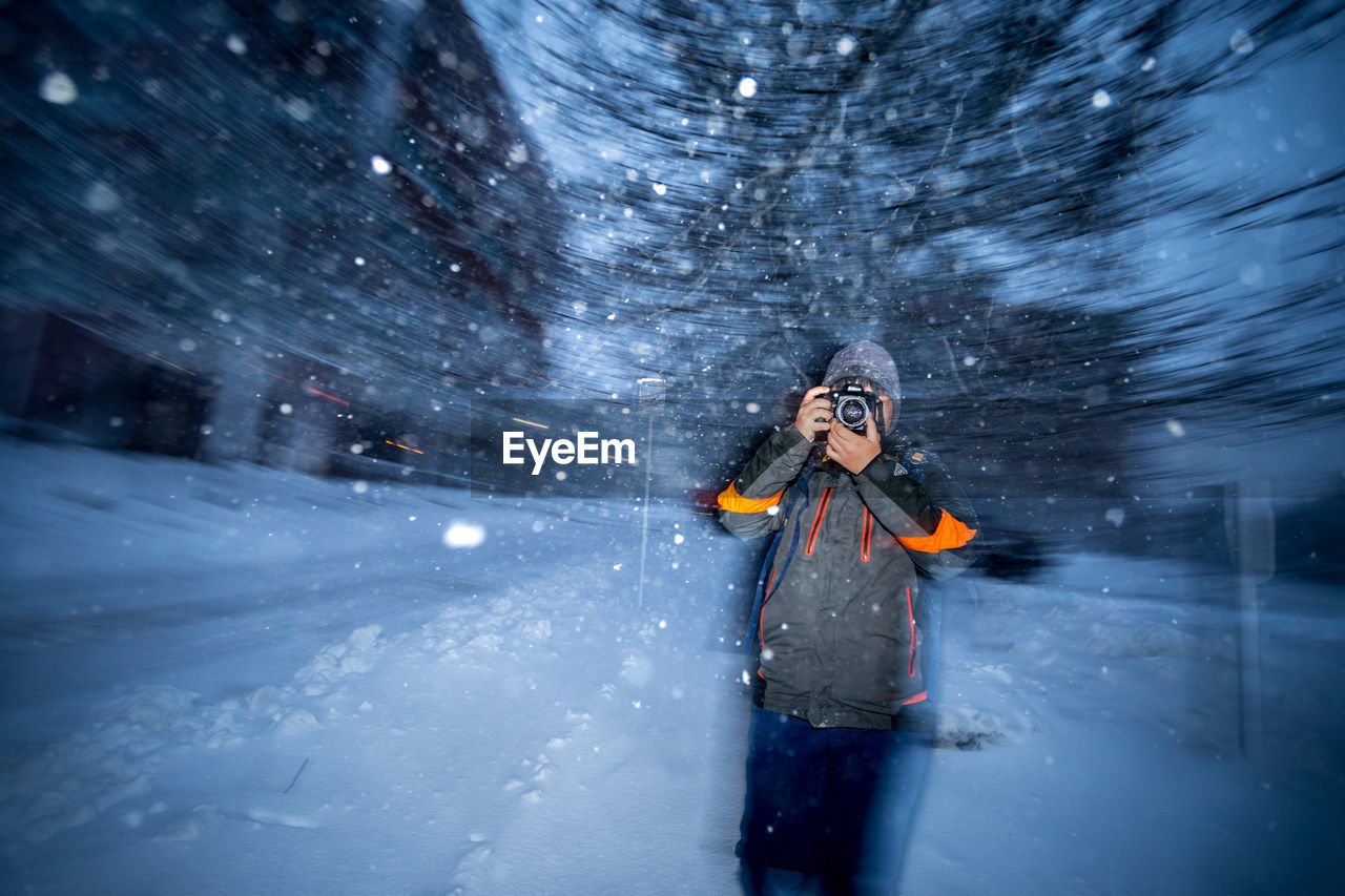 PERSON STANDING IN SNOW DURING WINTER