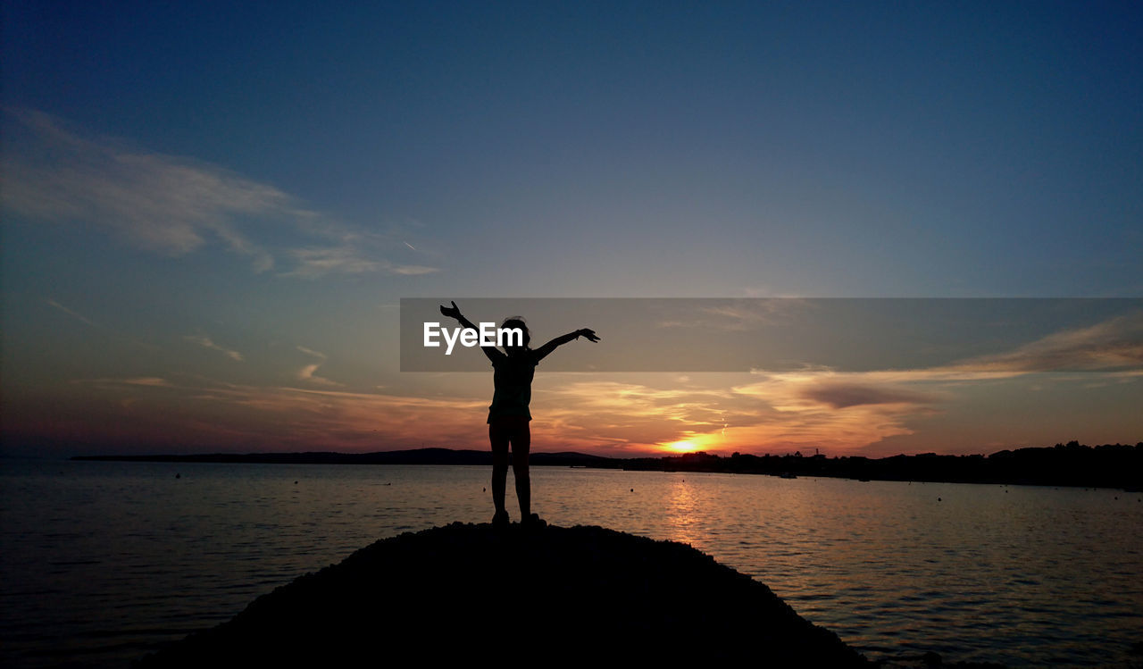 SILHOUETTE PERSON STANDING BY SEA AGAINST SKY