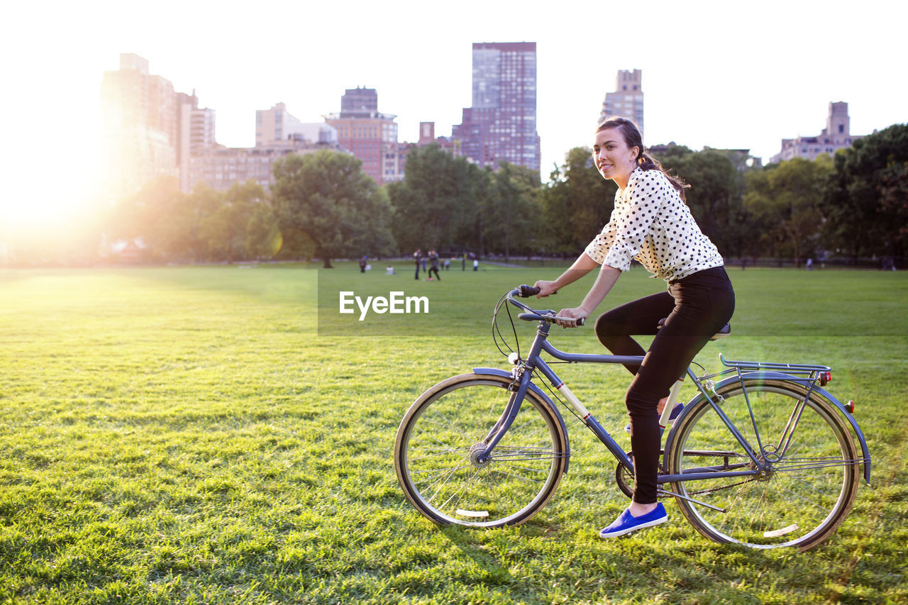 Side view of woman cycling in central park