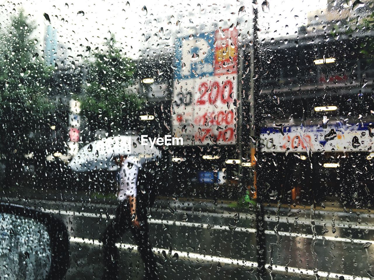 Road seen through wet window in rainy season