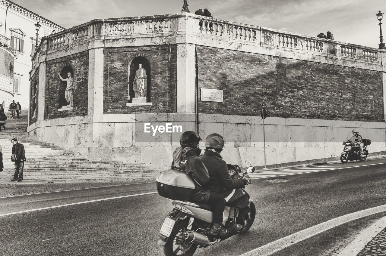 PEOPLE RIDING MOTORCYCLE ON ROAD