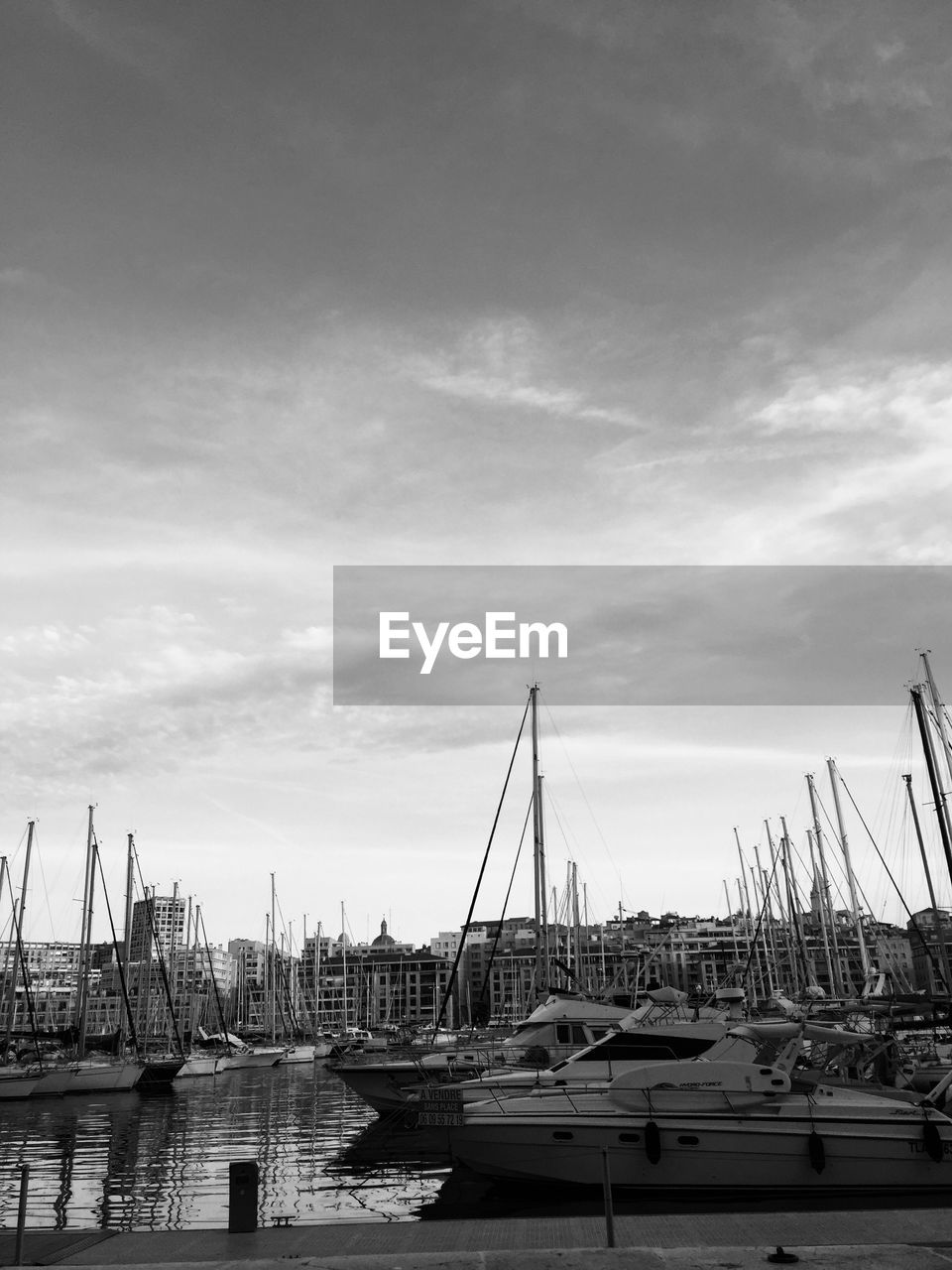 Boats moored at harbor against sky