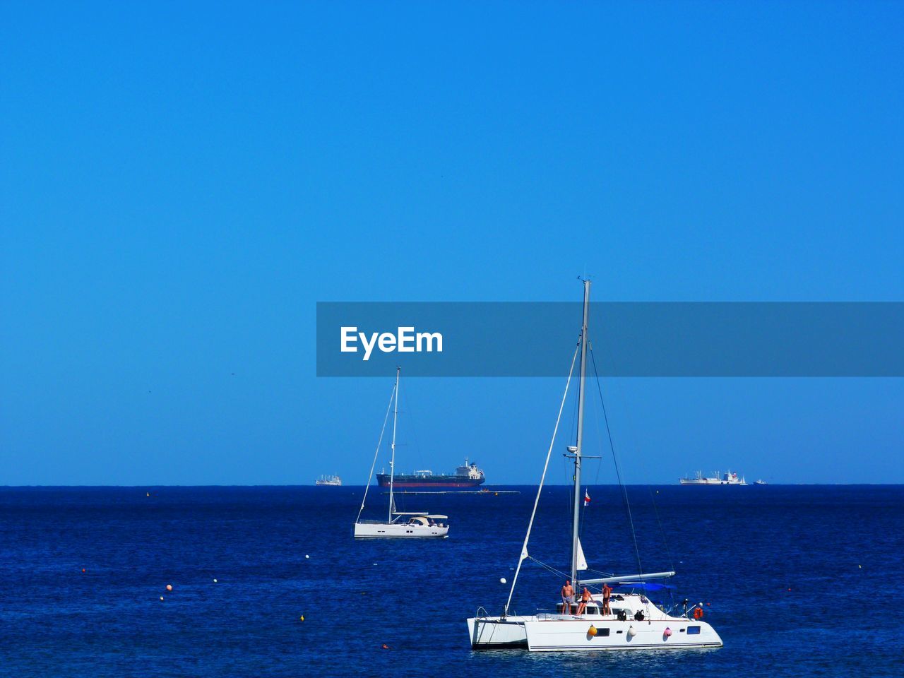 SAILBOATS SAILING ON SEA AGAINST CLEAR BLUE SKY