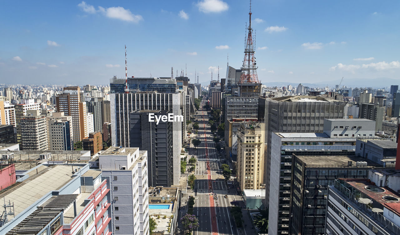 Aerial view of buildings in city against sky