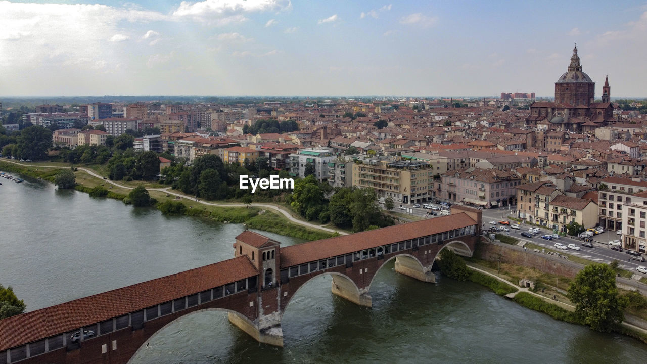 HIGH ANGLE VIEW OF BRIDGE OVER RIVER AND BUILDINGS IN CITY