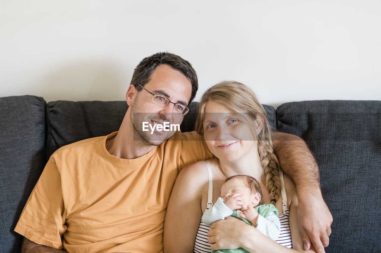 Portrait of friends smiling on sofa