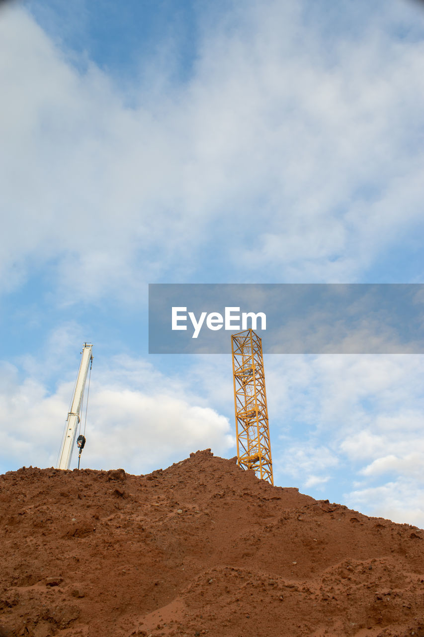 Low angle view of construction tower on land against sky