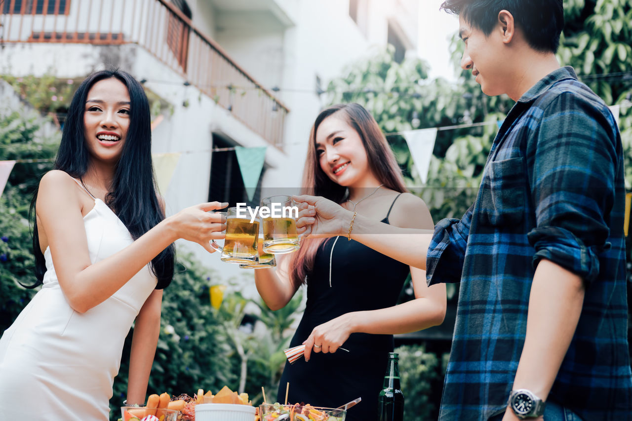 Smiling friends raising toast during celebration