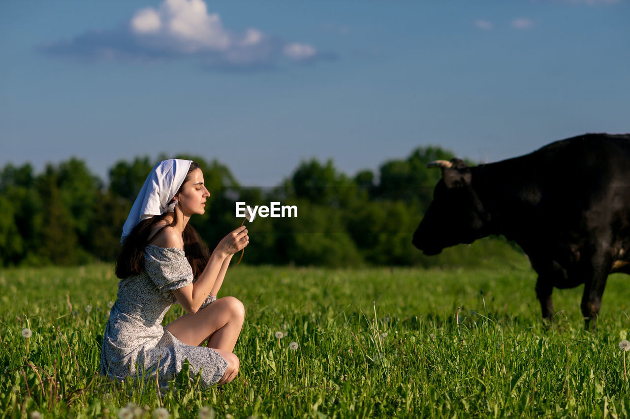 Portrait of young woman standing on field